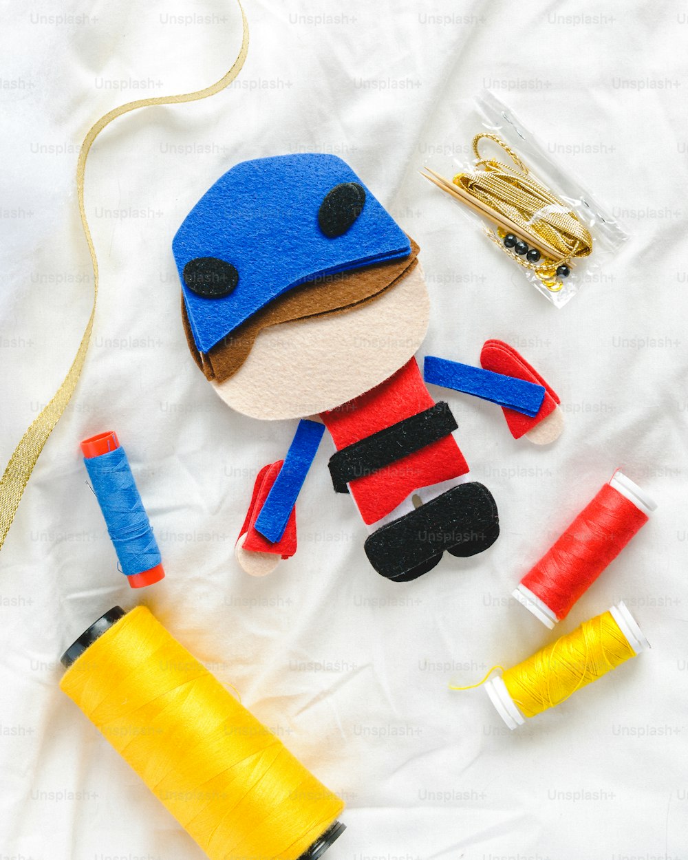 a toy with a blue hat and a yellow spool of thread
