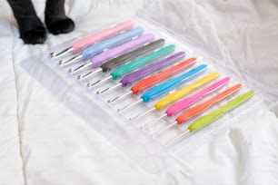 un récipient en plastique rempli de nombreux stylos de couleurs différentes
