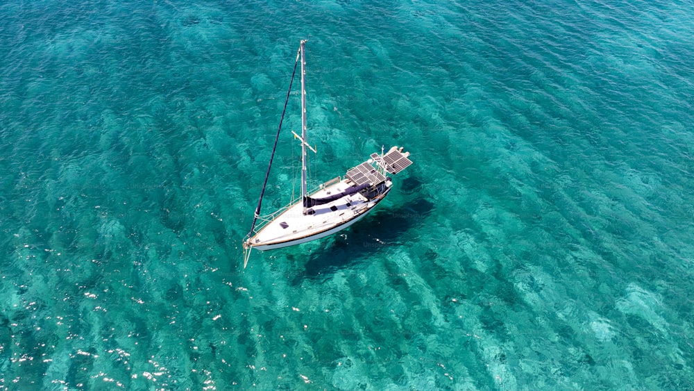 Ein Segelboot, das in klarem blauem Wasser schwimmt