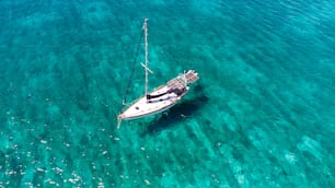um veleiro flutuando em águas azuis claras