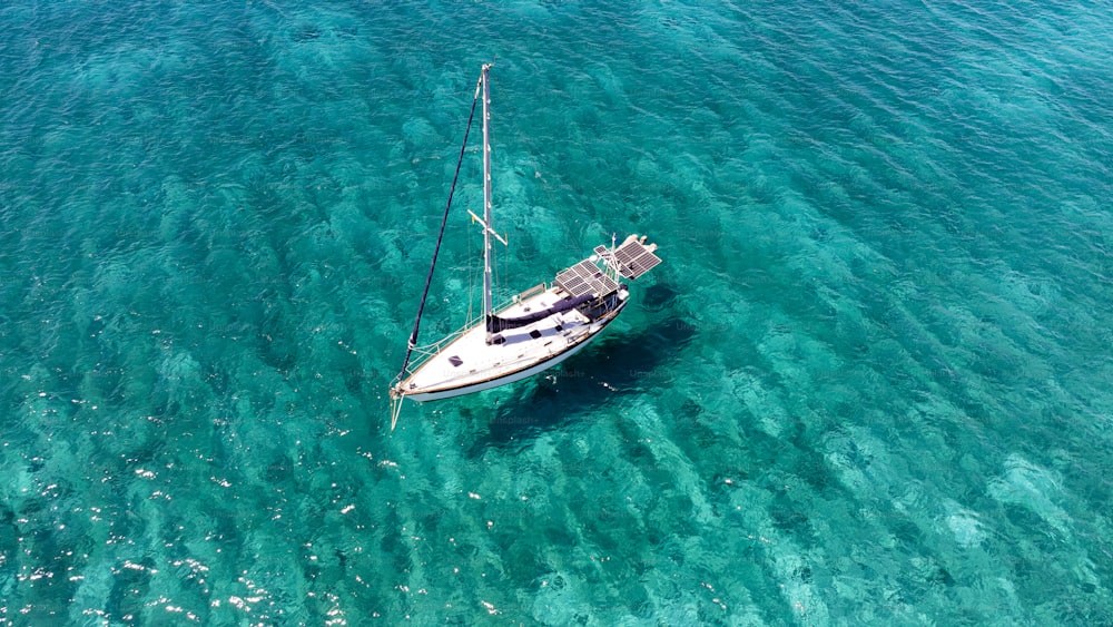 a sailboat floating in clear blue water