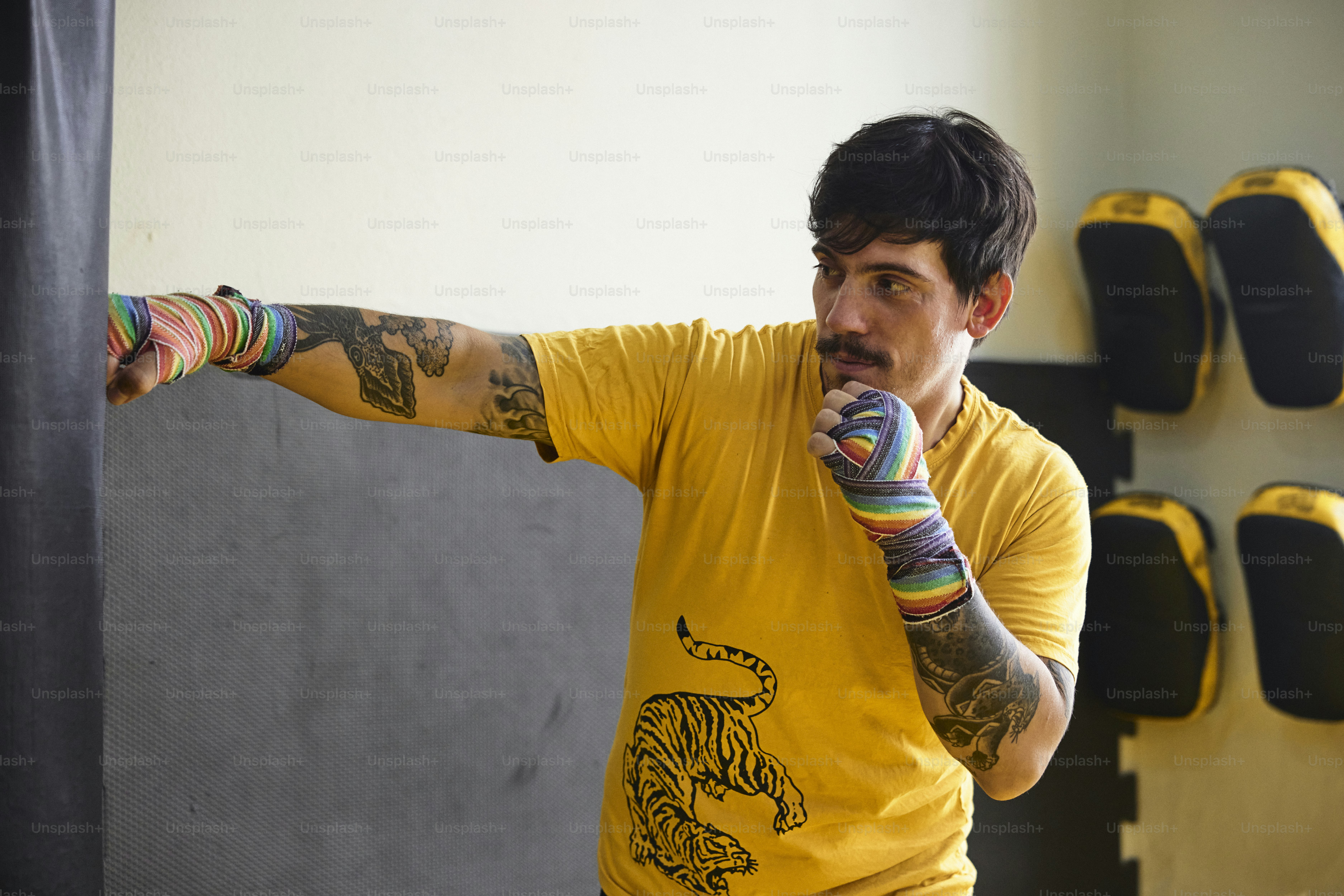 a man in a yellow shirt is holding a colorful object