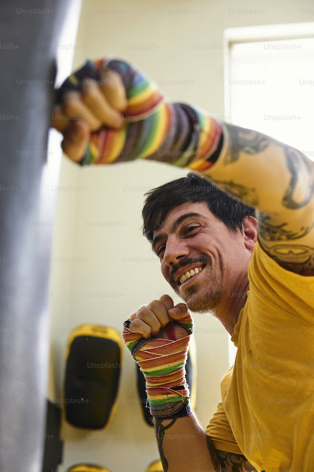 Un hombre con una camisa amarilla sostiene un objeto colorido