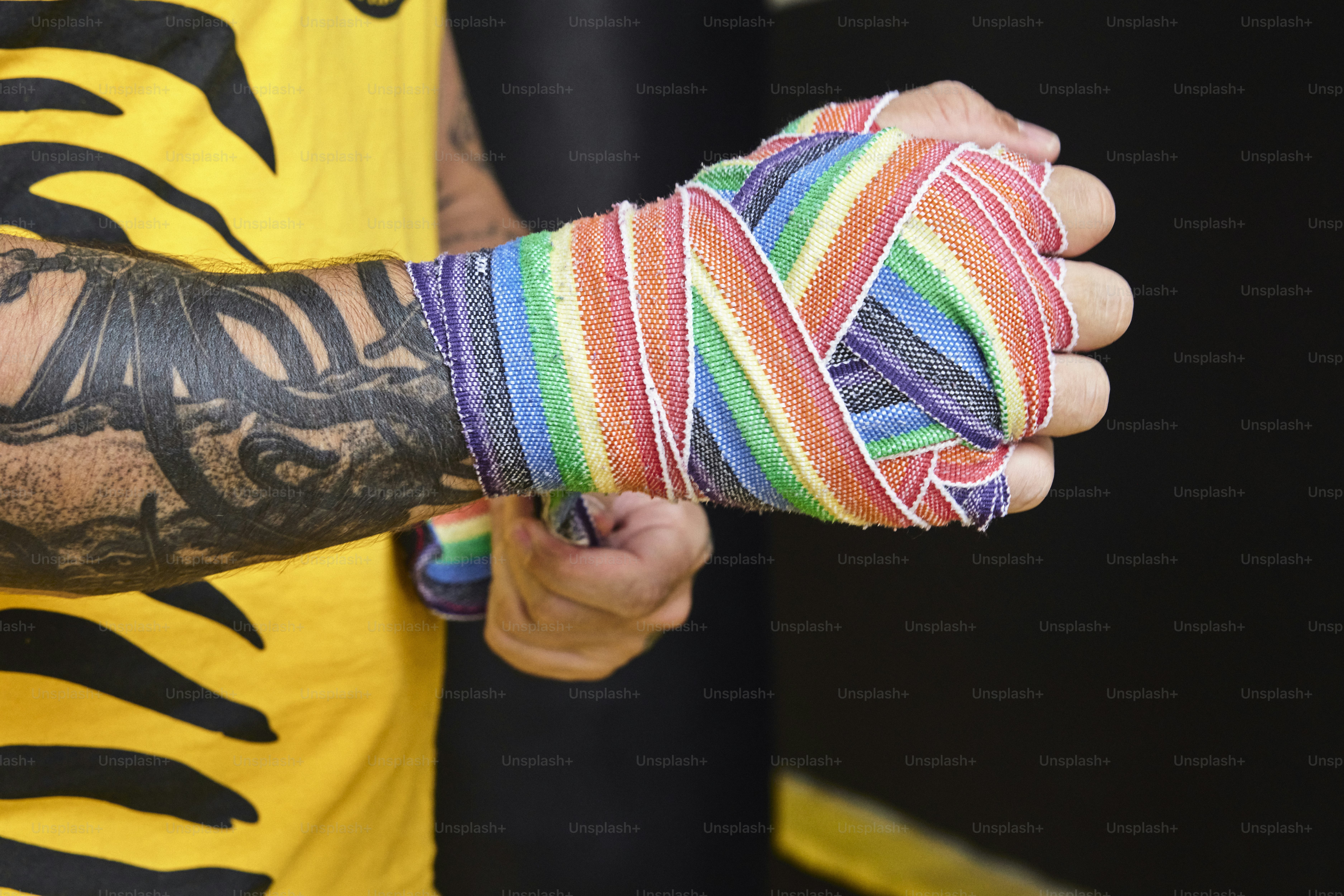 팔에 문신을 한 남자가 여러 가지 빛깔의 팔찌를 들고 있다
