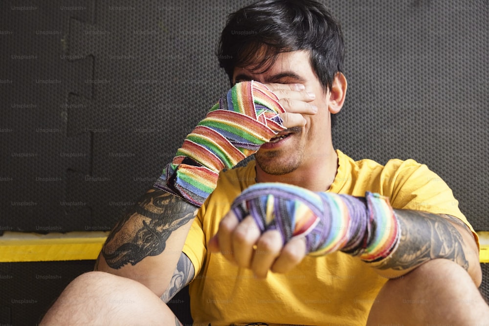 a man sitting on the ground holding a pair of gloves