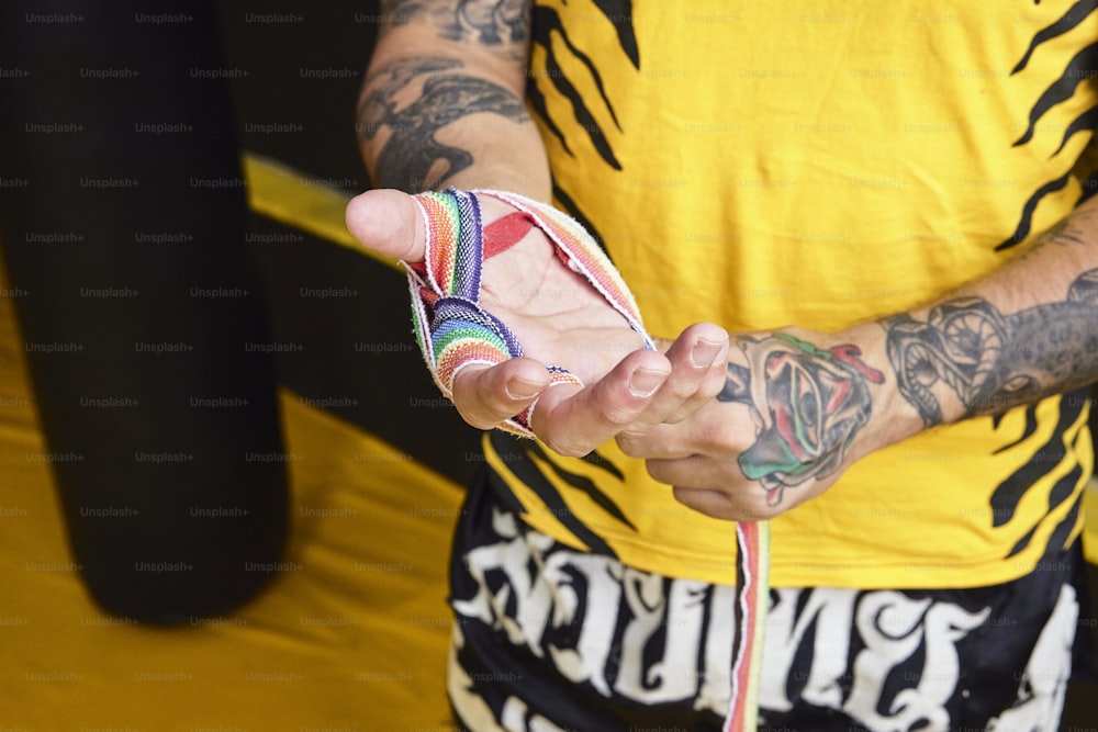 Un uomo tatuato che tiene un cellulare in mano