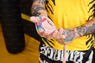 Un hombre tatuado sosteniendo un teléfono celular en la mano