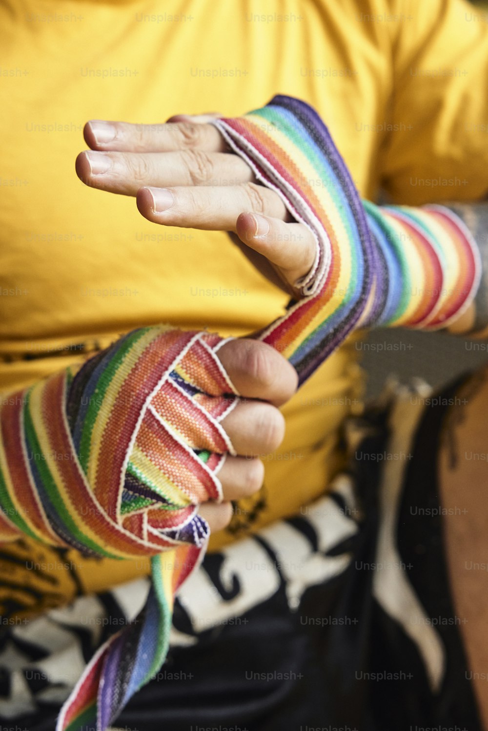 a person wearing a colorful wristband and a yellow shirt