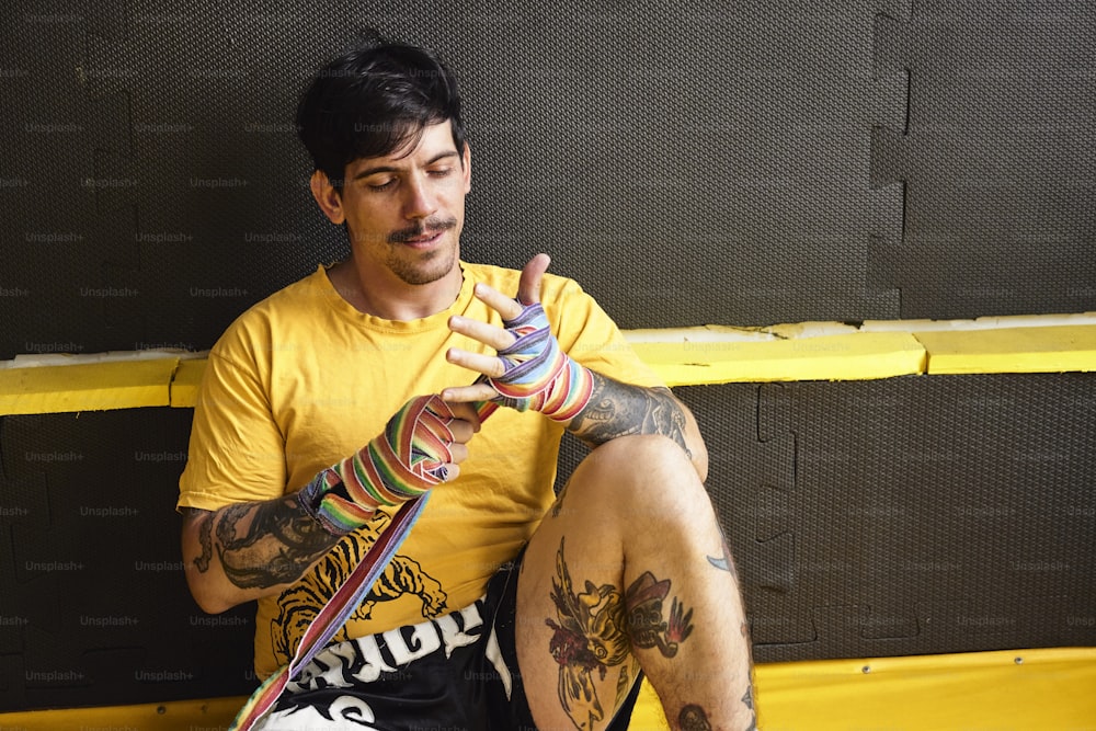a man with tattoos sitting on a bench