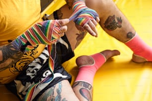 a man sitting on a yellow surface holding a pair of colorful socks