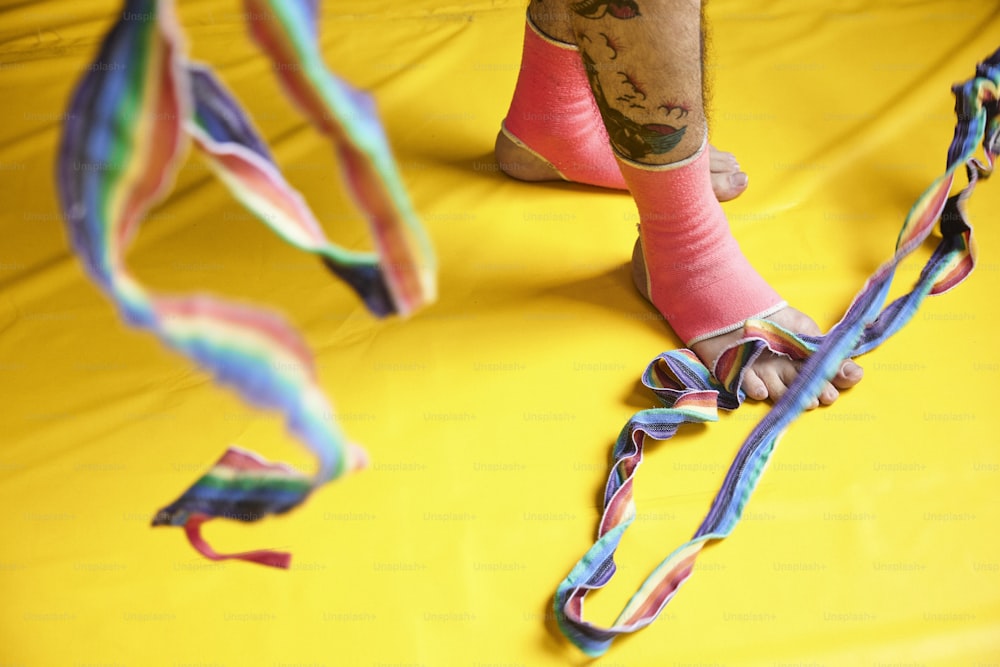a person standing on a yellow surface with a colorful ribbon