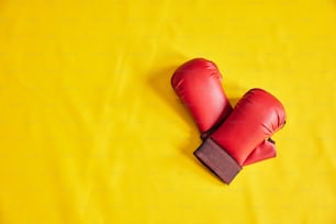a pair of red boxing gloves on a yellow background