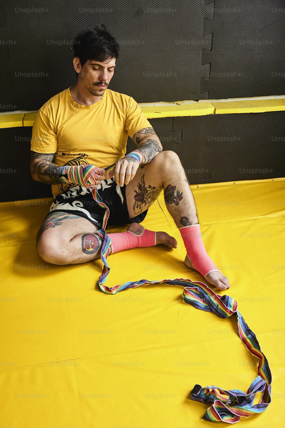 um homem sentado no chão com um par de meias coloridas