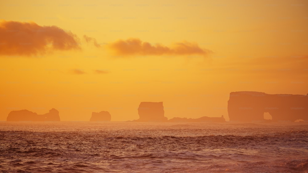 a large body of water with a sunset in the background