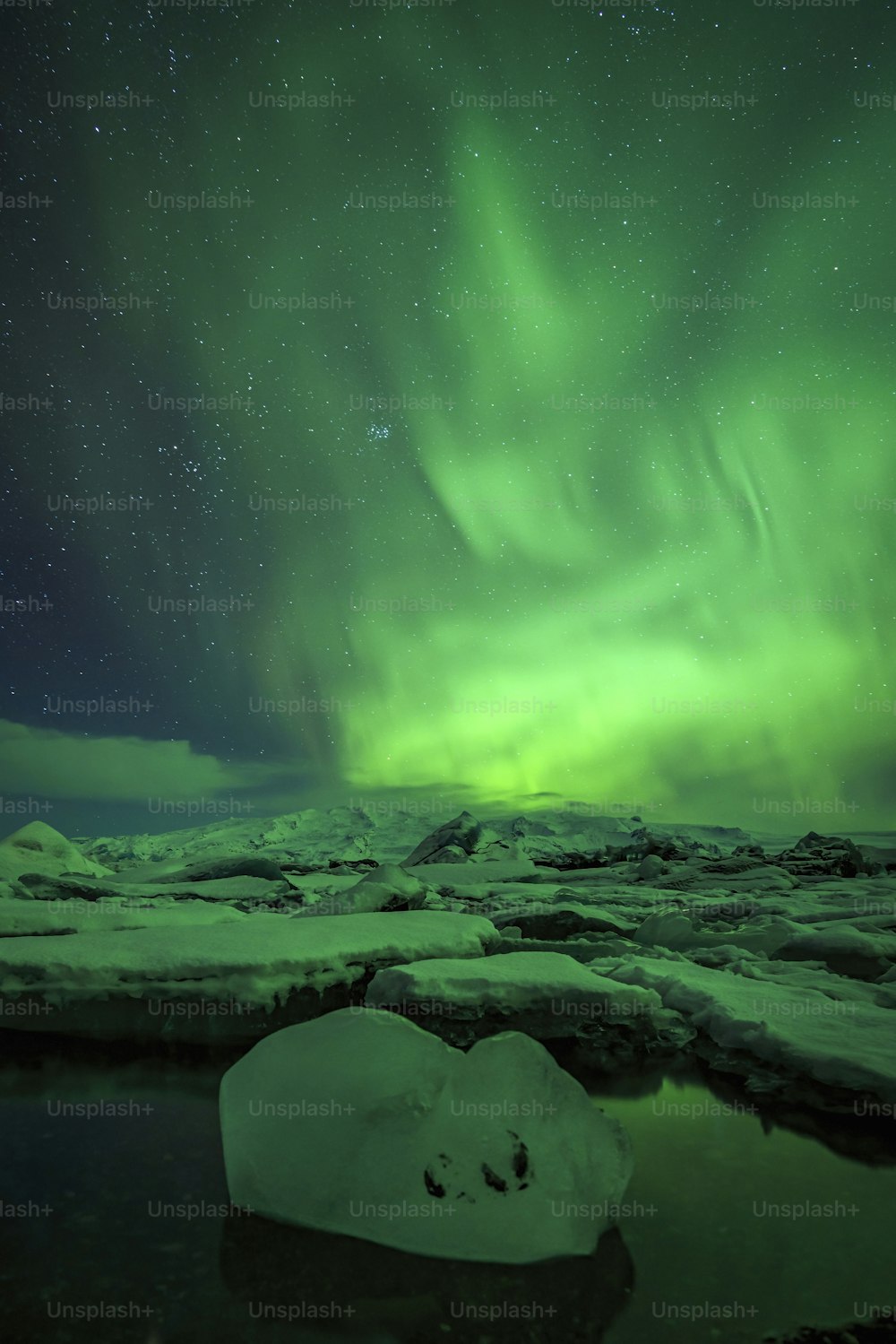 a green and blue aurora bore over a body of water