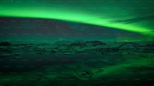 a green and black sky with the aurora in the background