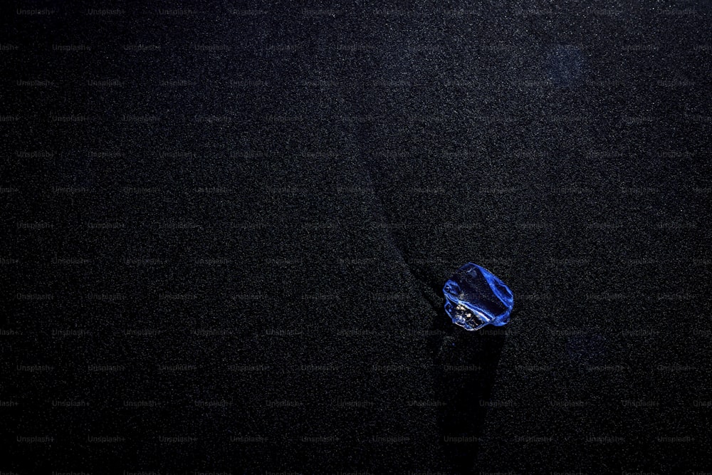 um objeto azul flutuando em cima de uma superfície preta