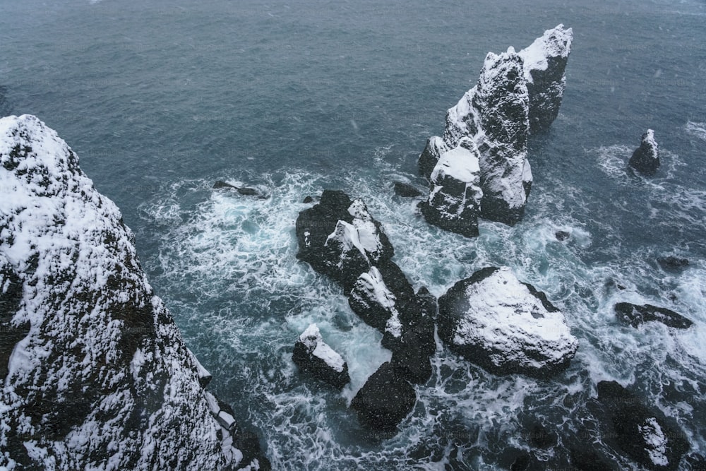 a large body of water surrounded by snow covered rocks