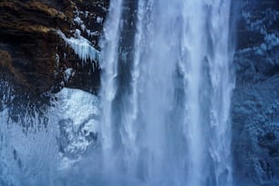 une grande cascade avec de la glace sur le côté