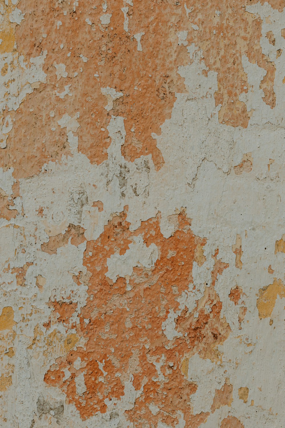 an orange and white wall with peeling paint