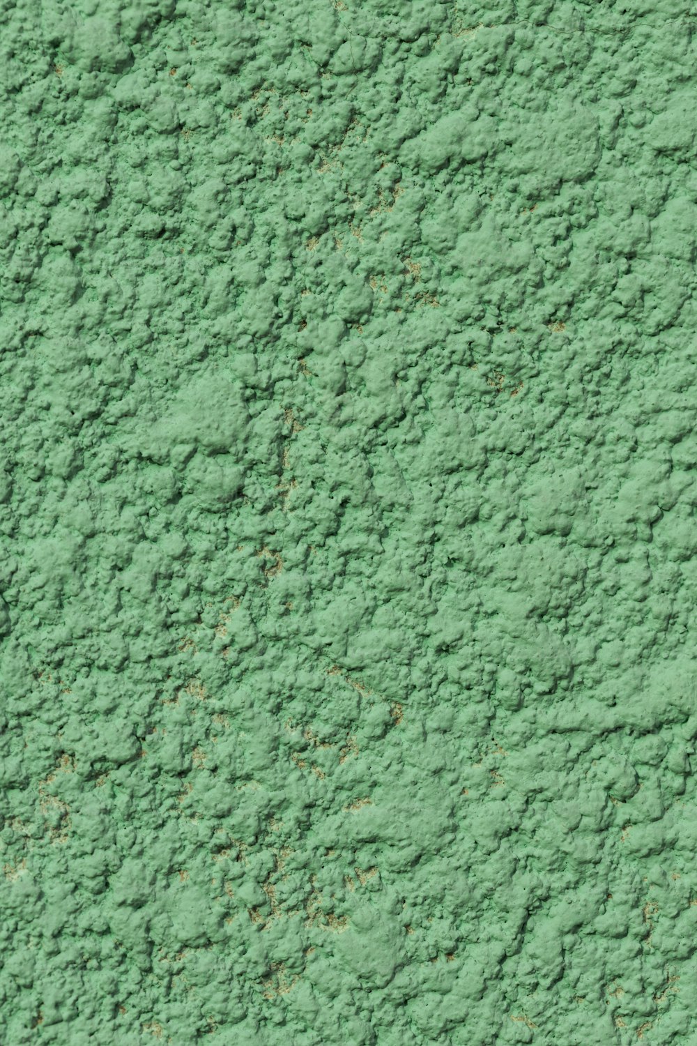 a close up of a green stucco wall
