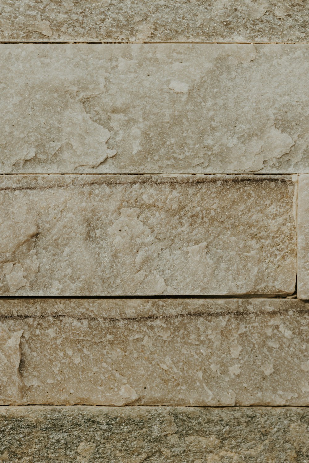 um close up de uma parede de pedra com um relógio sobre ele