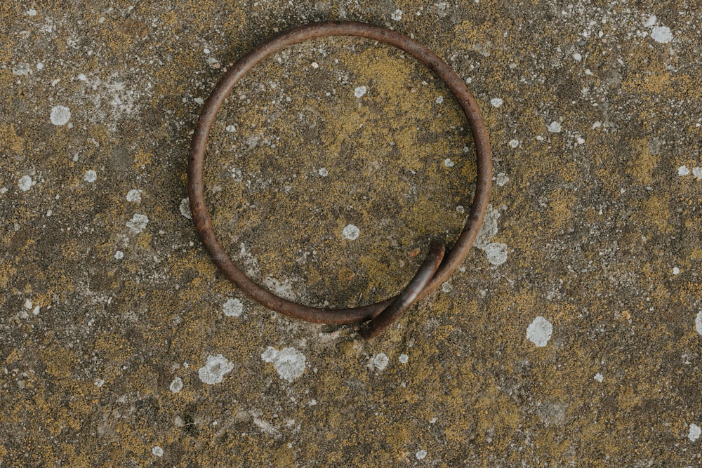 a rusted metal ring sitting on top of a cement ground