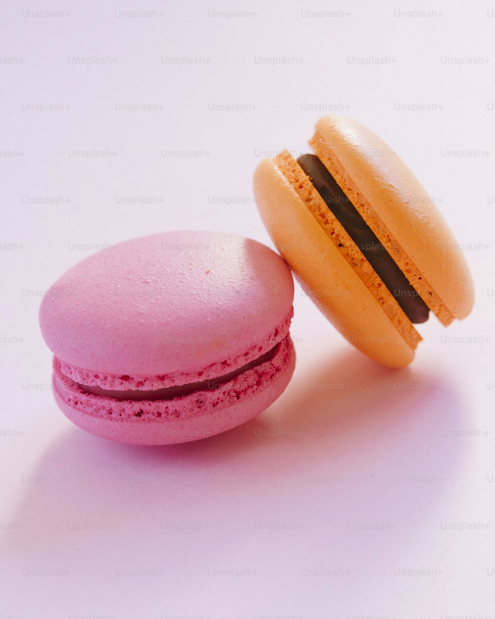 a pink macaroon and a yellow macaroon on a white background
