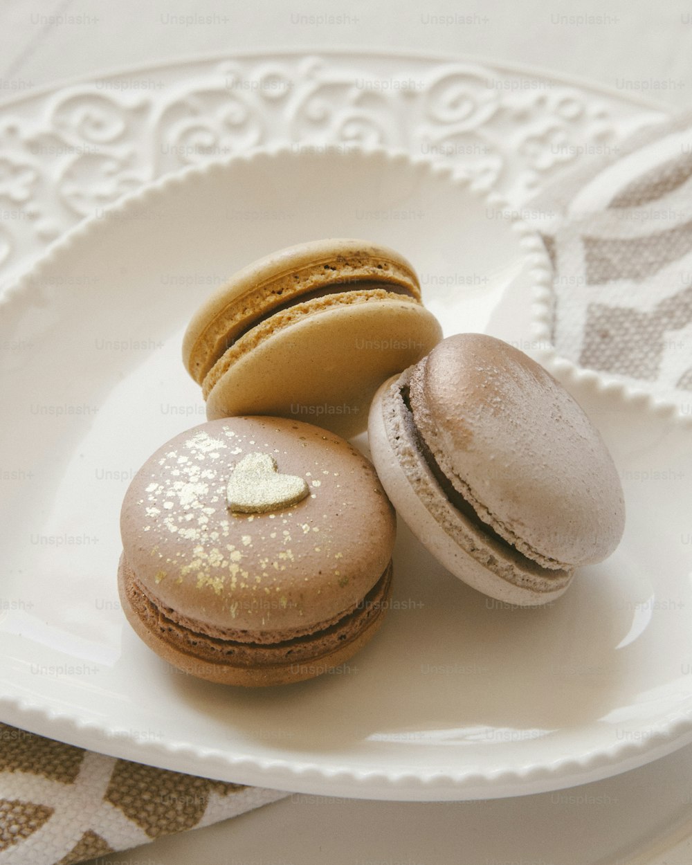 a white plate topped with three macaroons on top of a table