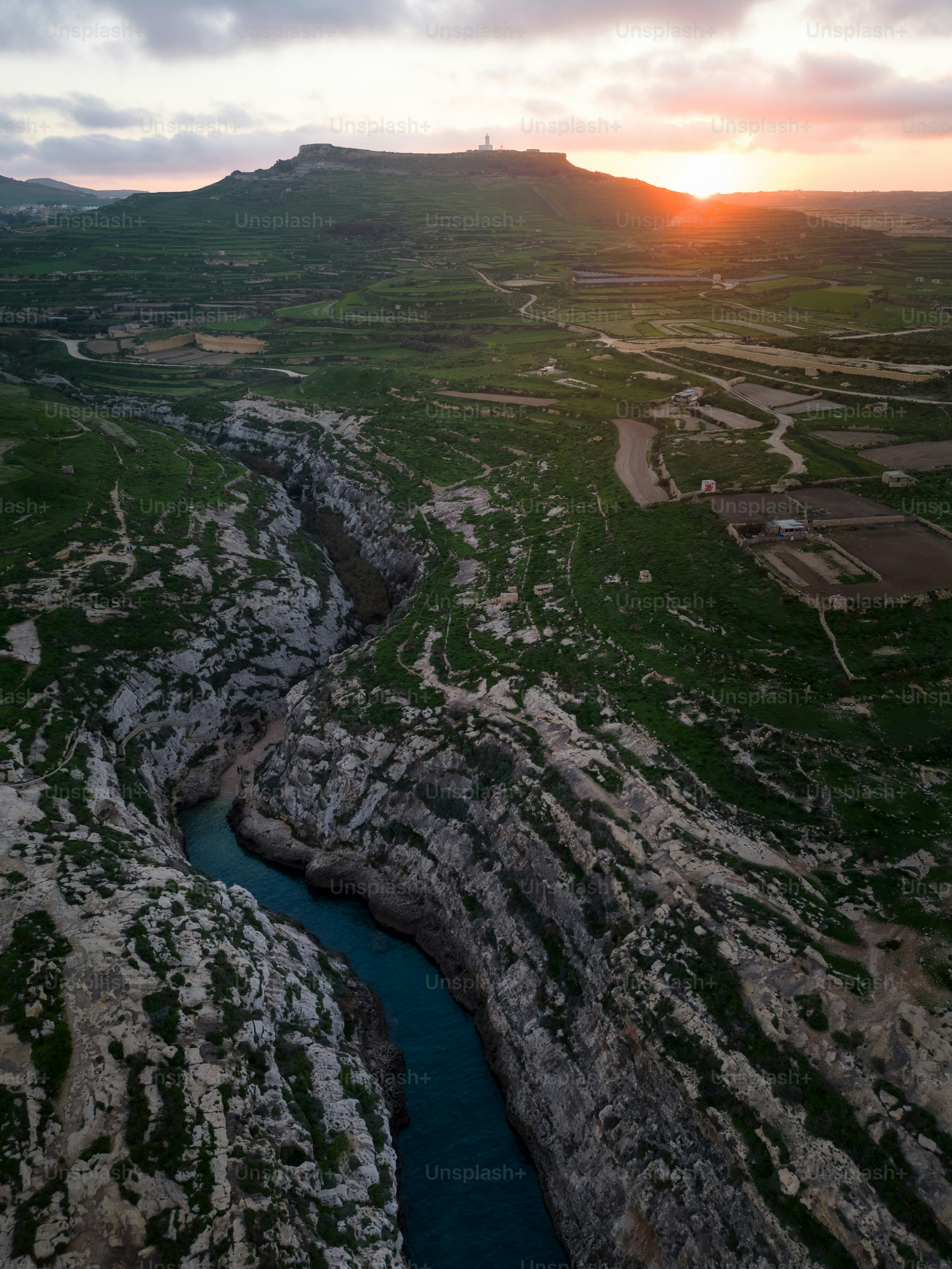 a river running through a lush green hillside