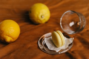 two lemons and a glass of water on a table