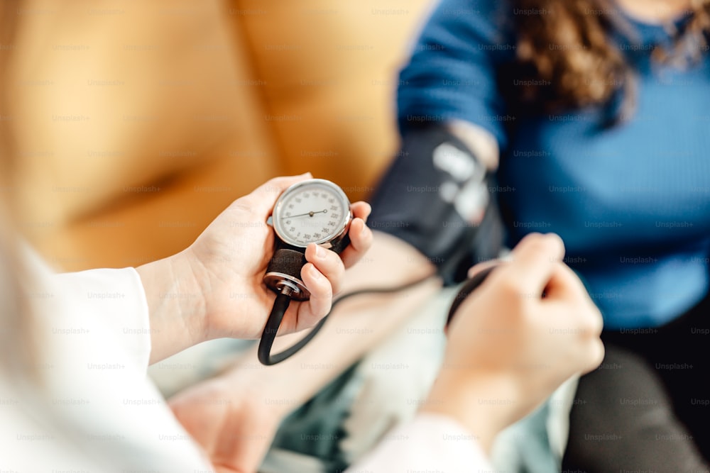 Una mujer está revisando su presión arterial con un esfiómetro