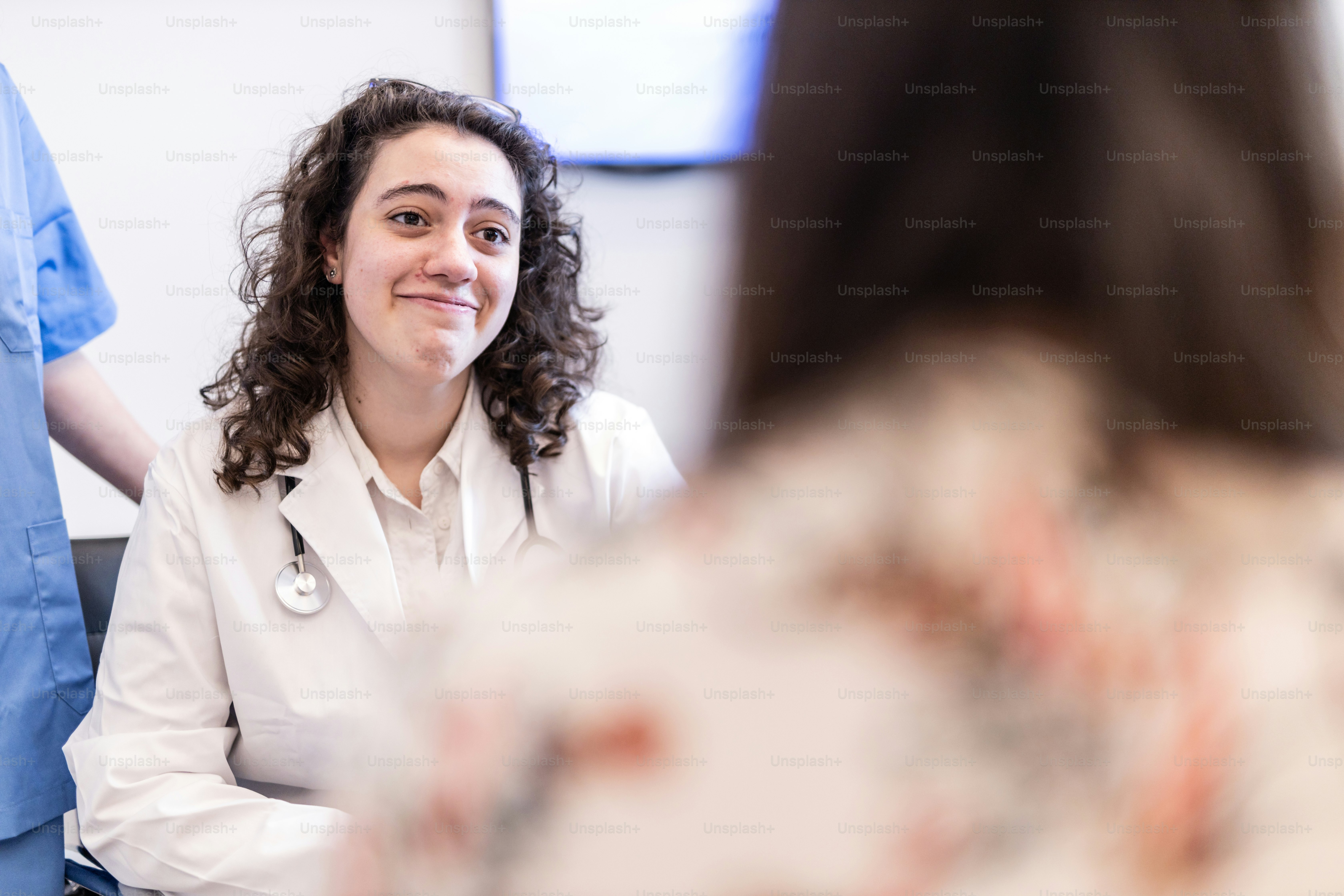 Una mujer con un estetoscopio sentada en una habitación