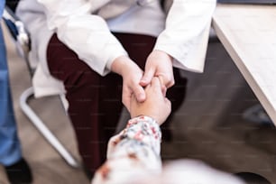 two people holding hands while sitting at a table