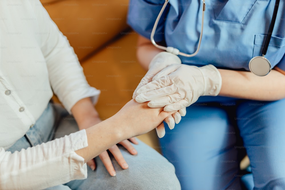 Una enfermera sosteniendo la mano de un paciente