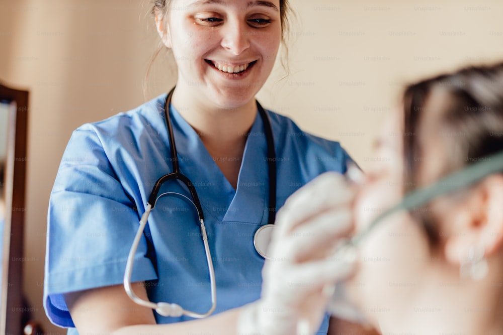 a woman in scrubs smiles as she holds a tube