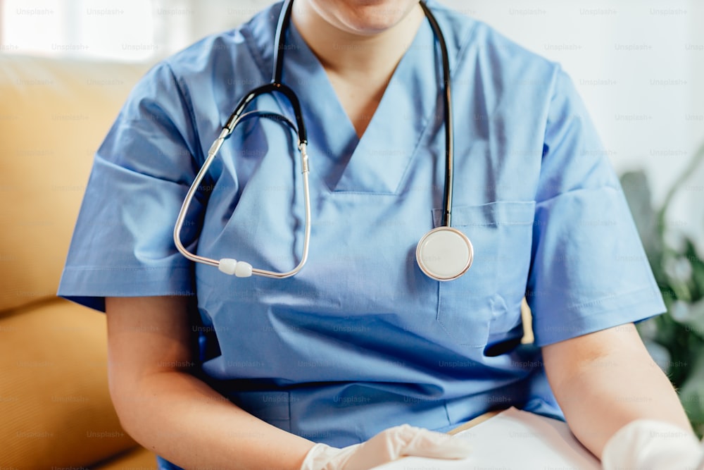 a woman in scrubs sitting on a couch with a stethoscope