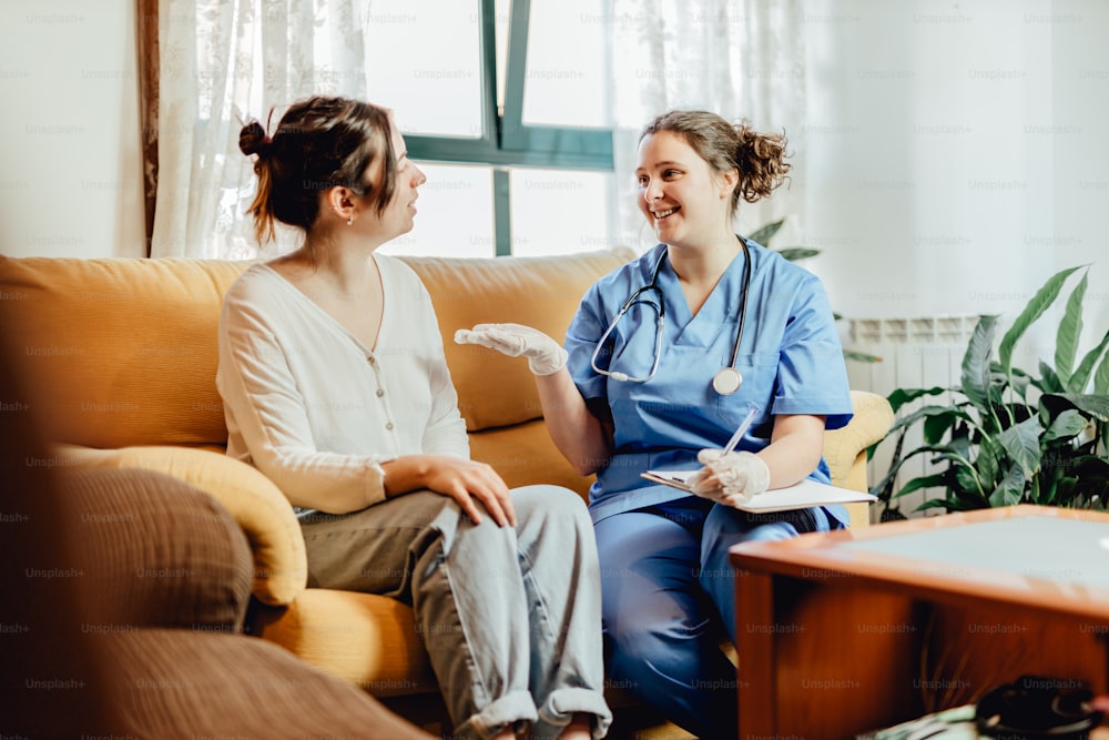 two women sitting on a couch talking to each other