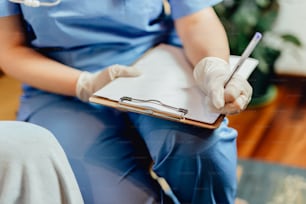 a person in scrubs writing on a clipboard