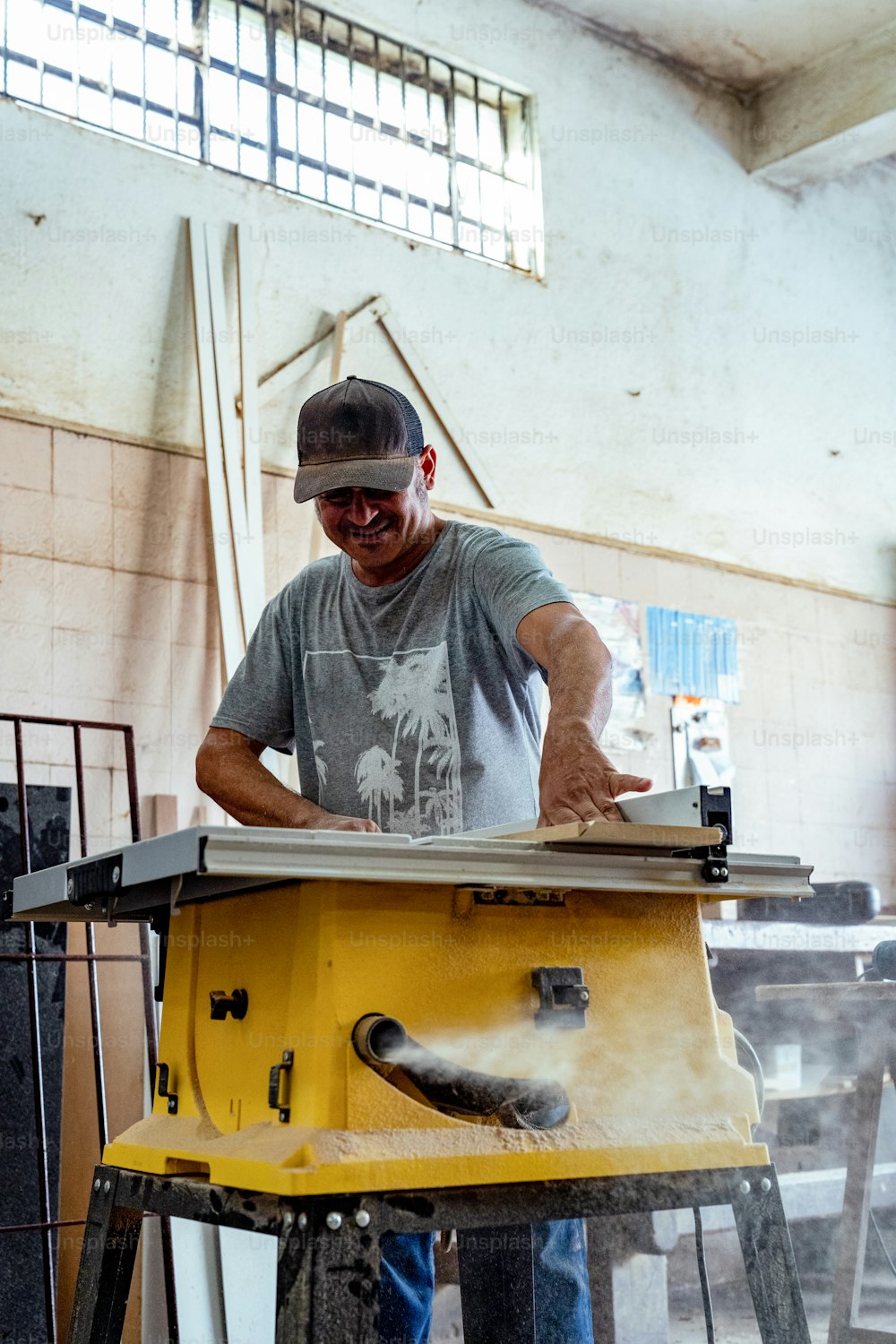 um homem que trabalha em uma mesa serrando um pedaço de madeira