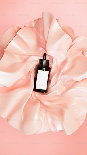 a bottle of perfume on a pink background