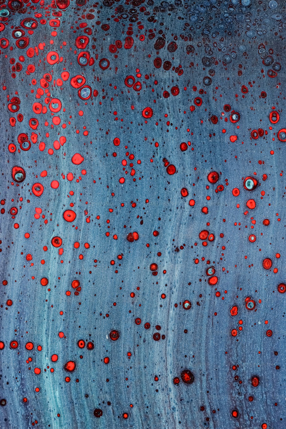 a close up of a blue surface with red dots