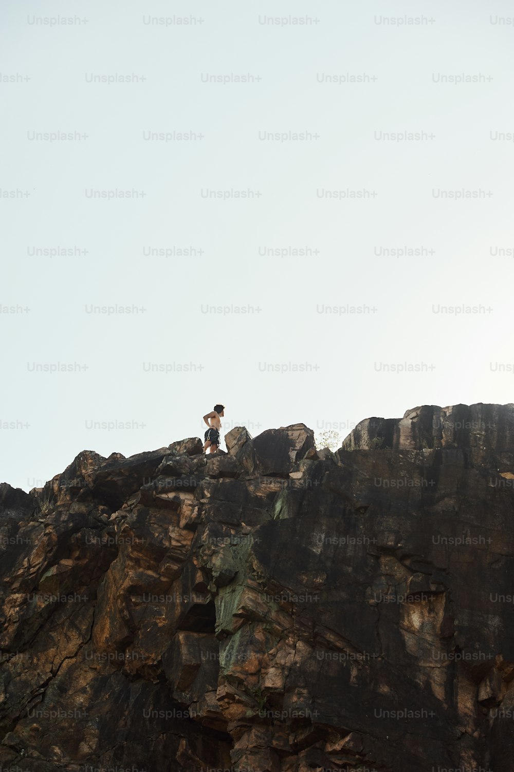 a man standing on top of a rocky cliff