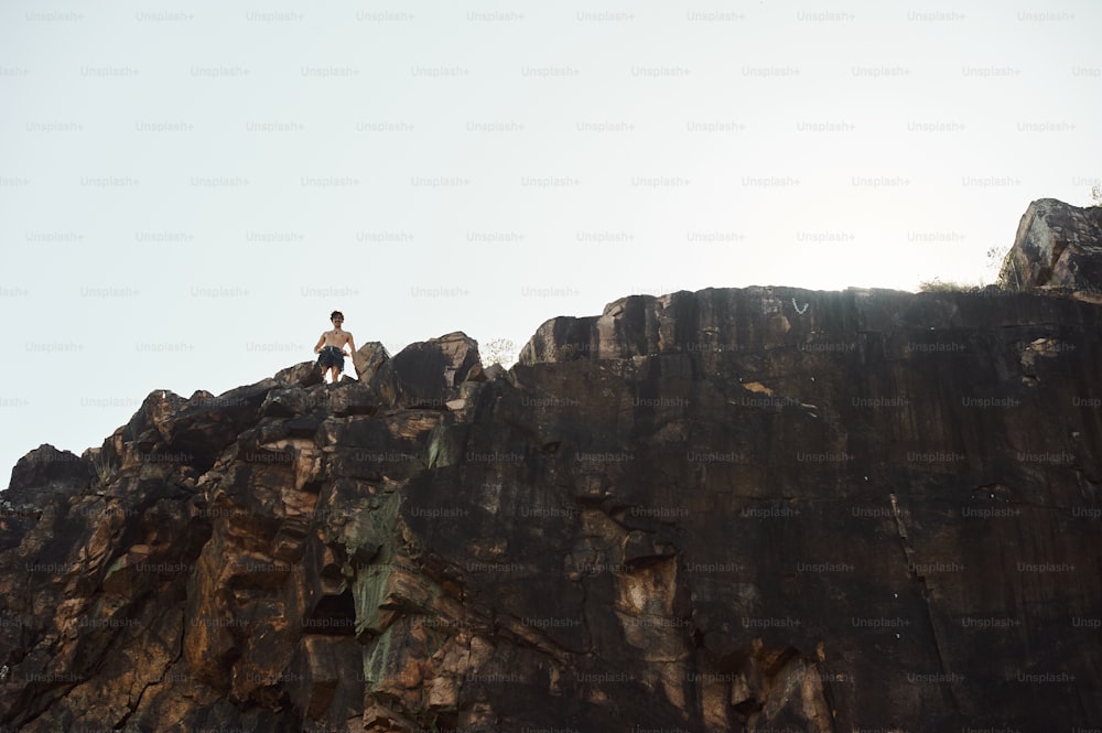 a man standing on top of a rocky cliff