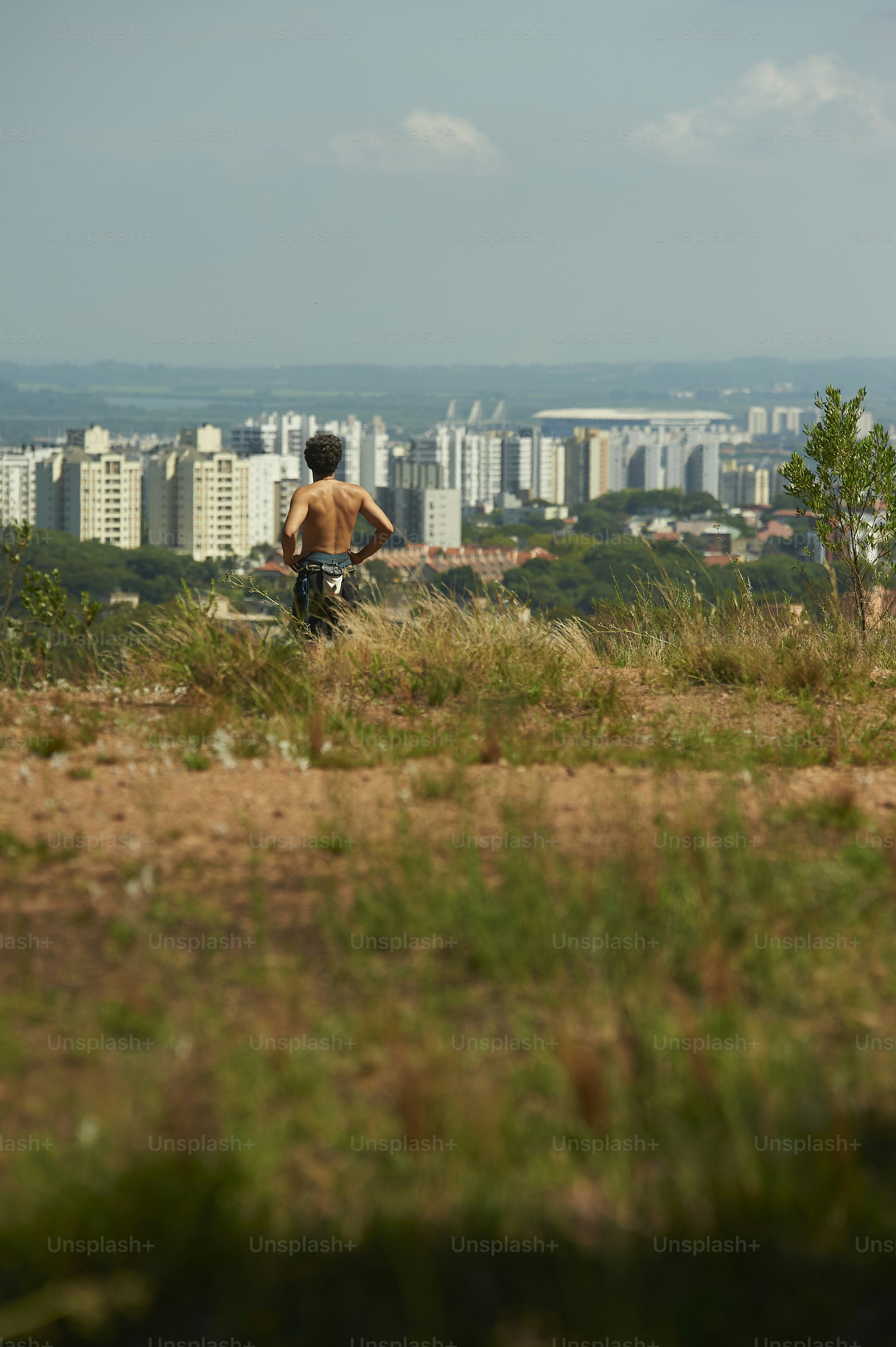 a man standing on top of a lush green hillside