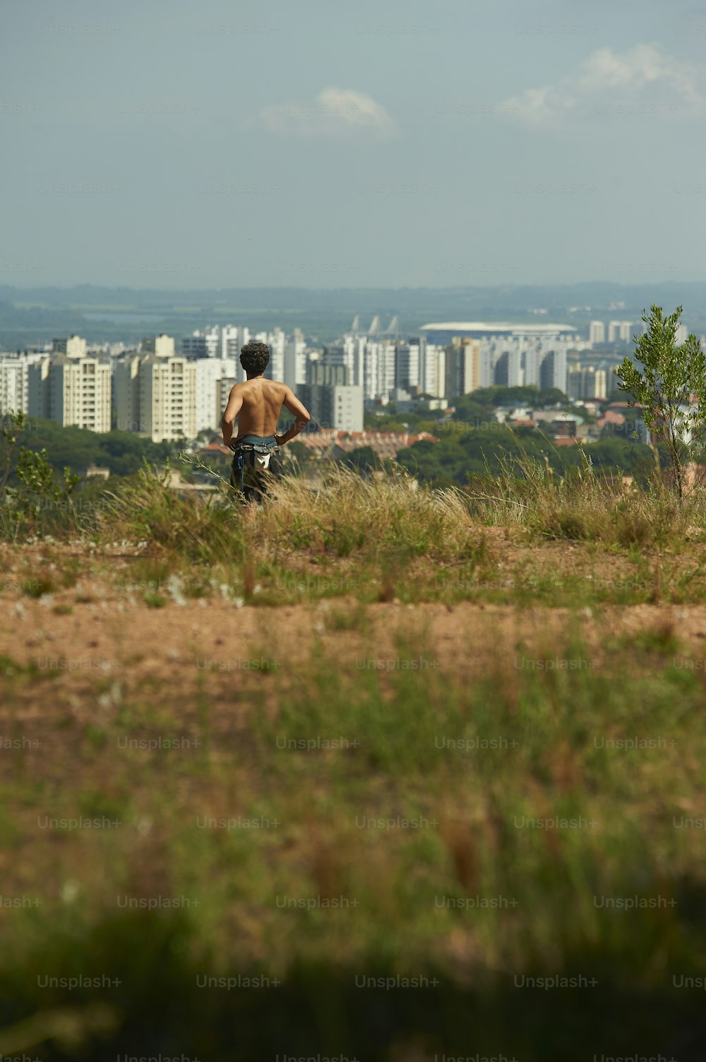 a man standing on top of a lush green hillside