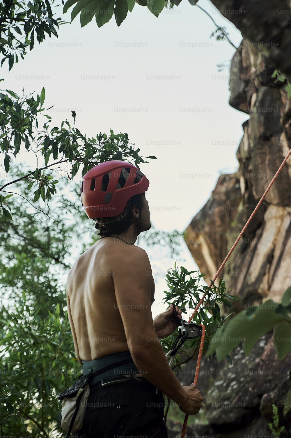 a man with a red helmet is climbing