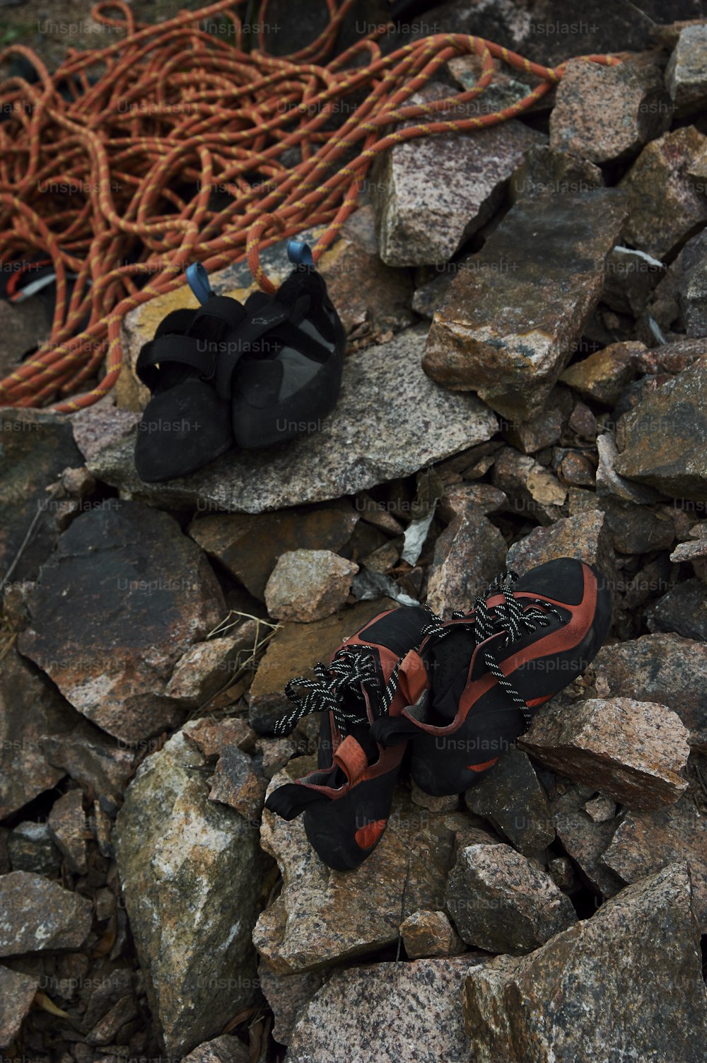 a pair of shoes sitting on top of a pile of rocks