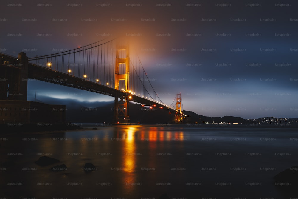 the golden gate bridge is lit up at night