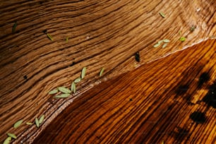 a close up of a wooden surface with leaves on it